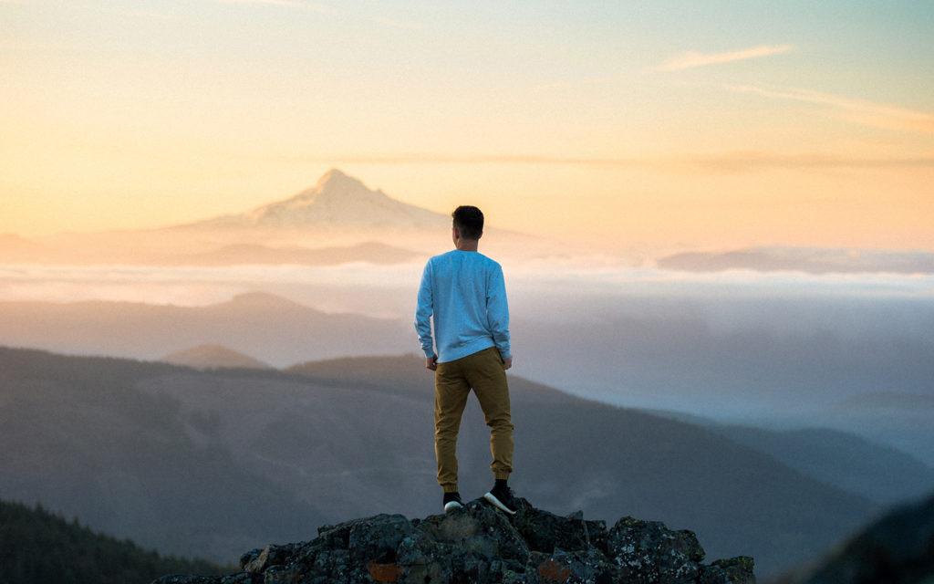 man standing on cliff edge